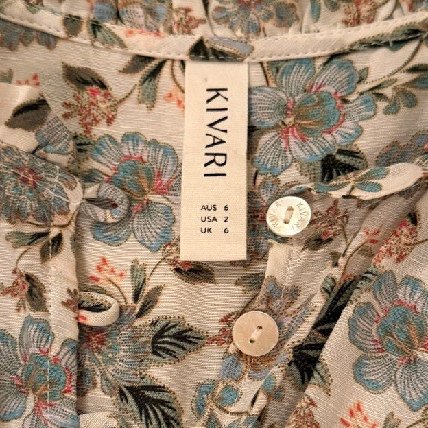 Floral patterned shirt with buttons and a visible brand label on a white background