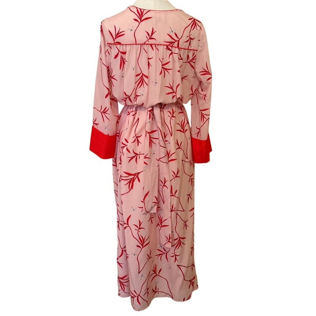 Mannequin wearing a pink dress with red floral patterns on a white background
