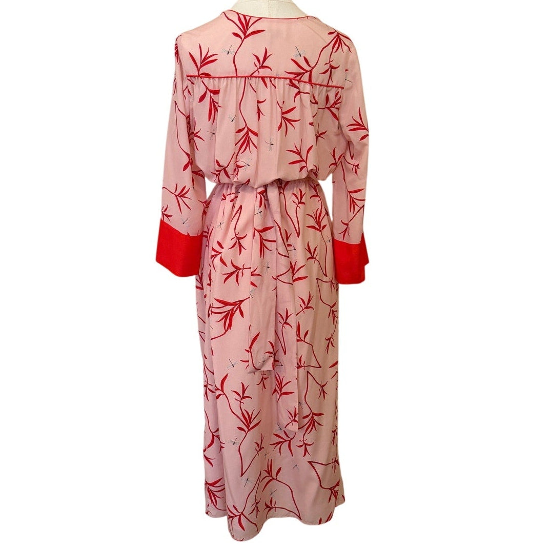 Mannequin wearing a pink dress with red floral patterns on a white background
