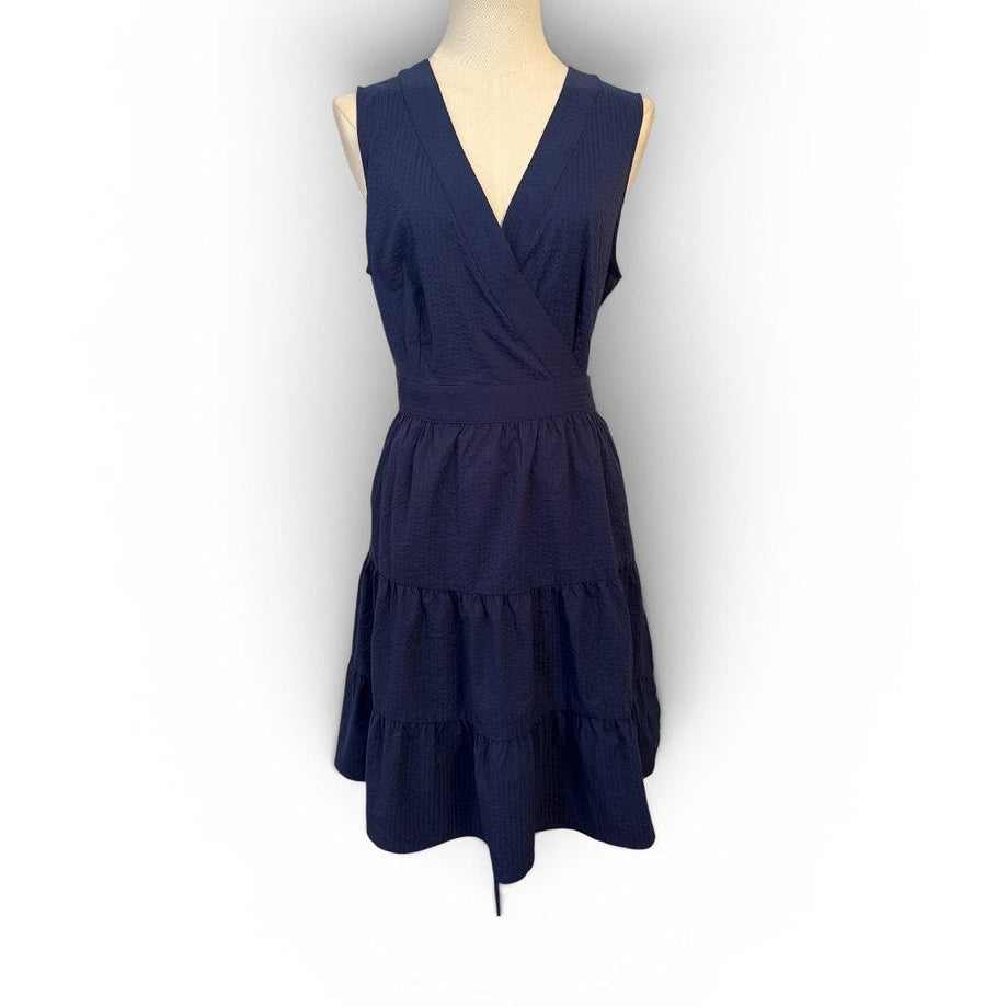 Navy blue dress on a mannequin against a white background