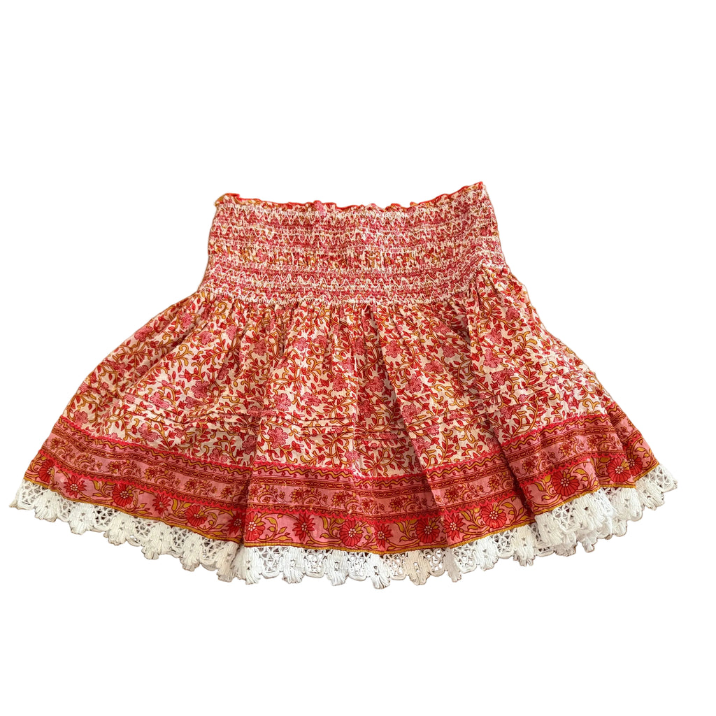 Red patterned skirt with white lace hem on a wooden floor