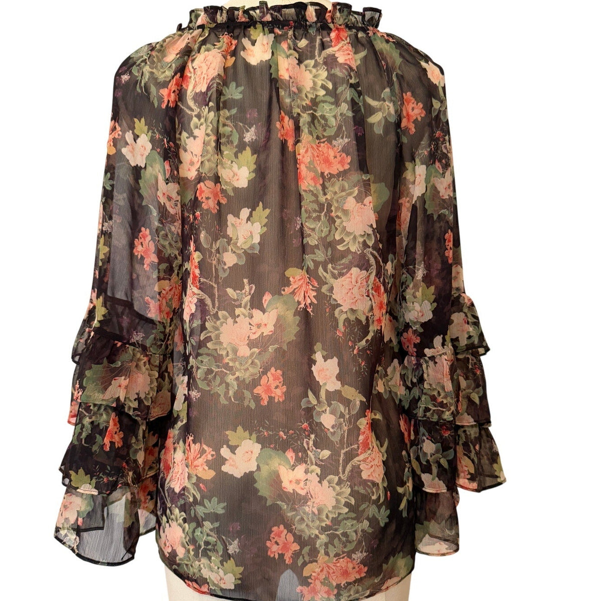 Floral blouse on a mannequin against a white background
