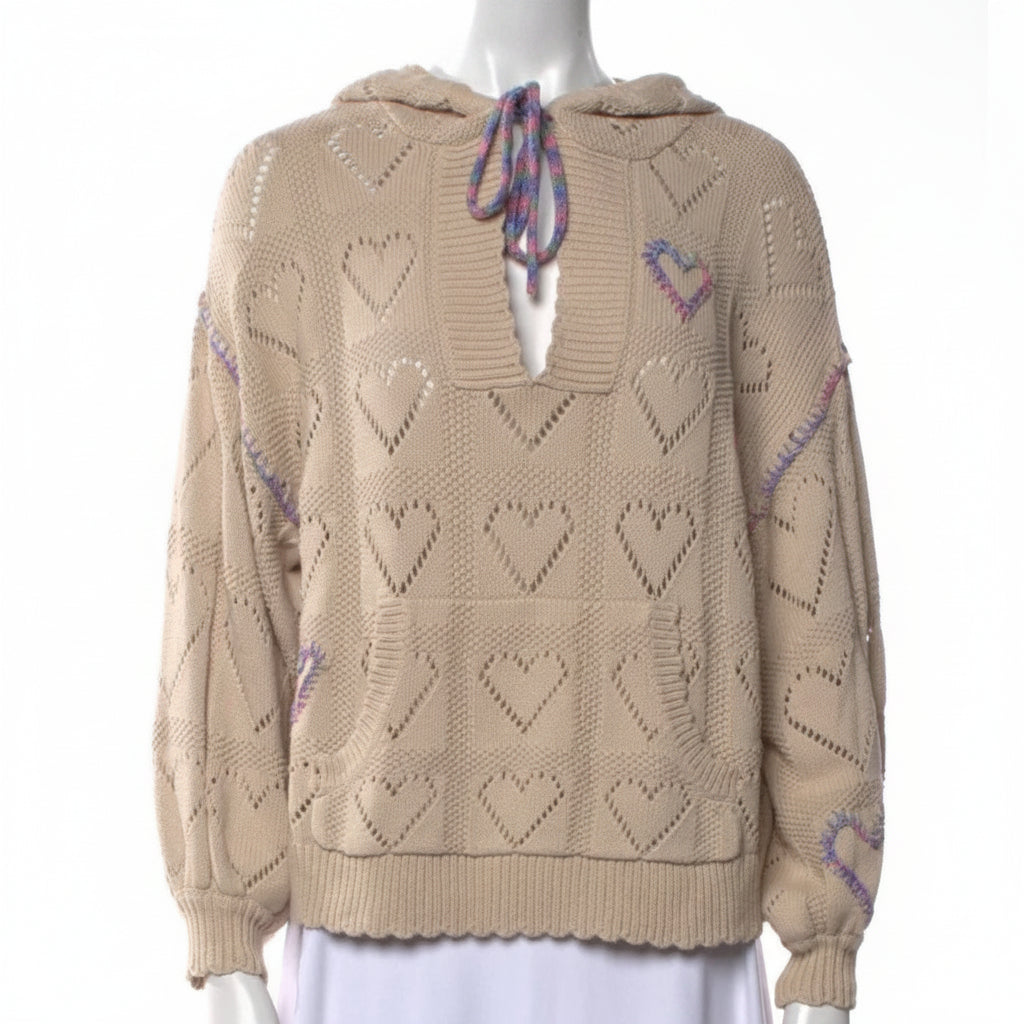 Beige sweater with heart patterns on a mannequin against a white background